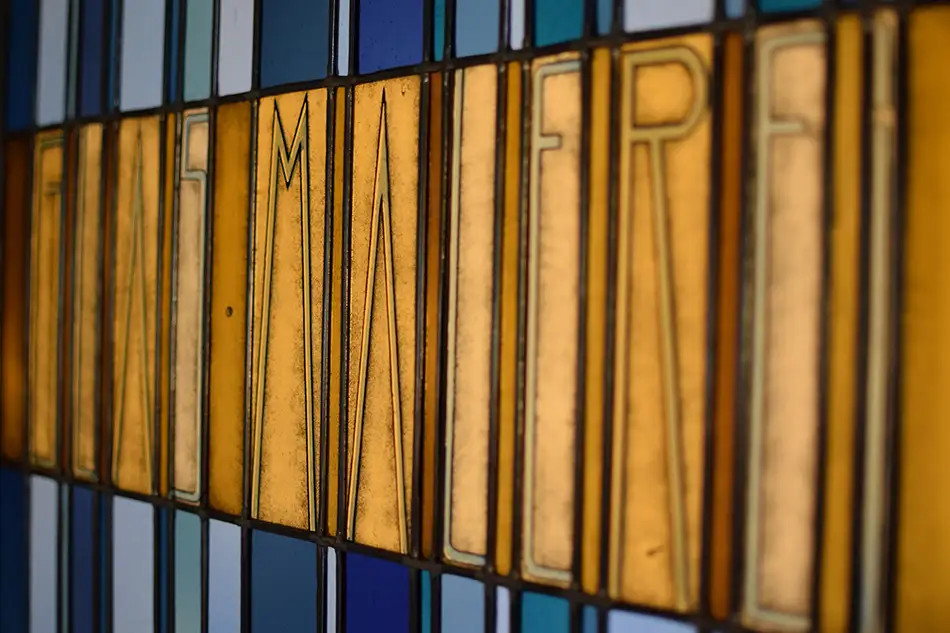 Stained glass window at Tiroler Glasmalerei with Art Nouveau lettering