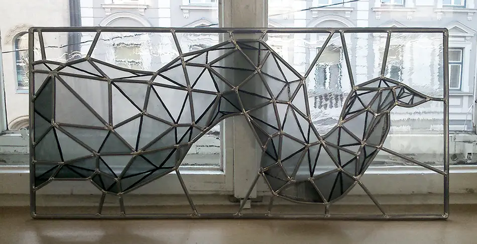 Detail monochromer Bleiverglasungen mit geometrischem Muster in Altbau-Eingangstüre und in Oberlichten