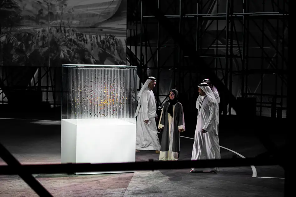 Ausstellungsansicht mit Personen von anamorpher Skulptur aus Glas von Thomas Medicus für die EXPO2020 in Dubai