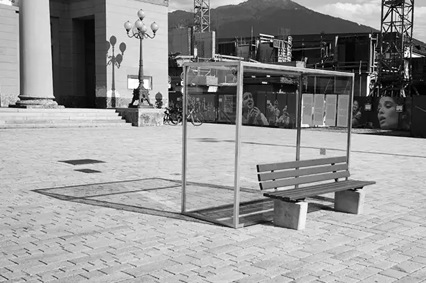 Kunstinstallation im öffentlichen Raum die eine eingeglaste Parkbank zeigt mit dem Titel Nehmen Sie Platz! mit von unbekannten Personen befreiter Parkbank