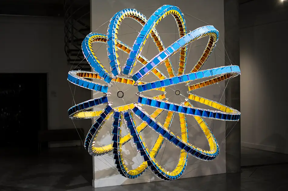 Ausstellungsansicht von kugelförmiger Kunstinstallation LudoModuL welche mittels verschiedenfärbiger Holz-Würfel mit Farbänderungen spielt