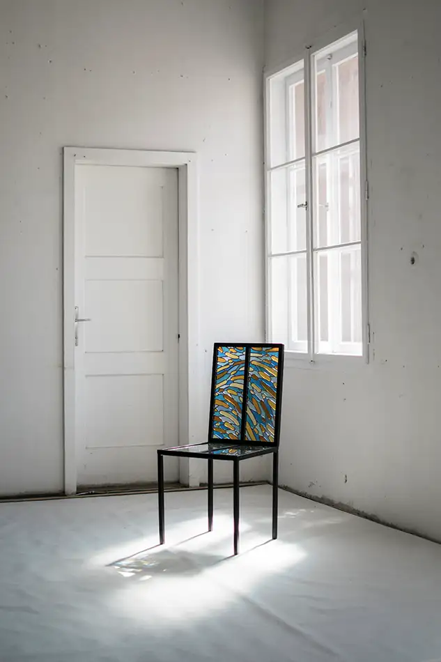 Stuhl-Kunstobjekt aus traditioneller Bleiverglasungs-Technik vor Fenster