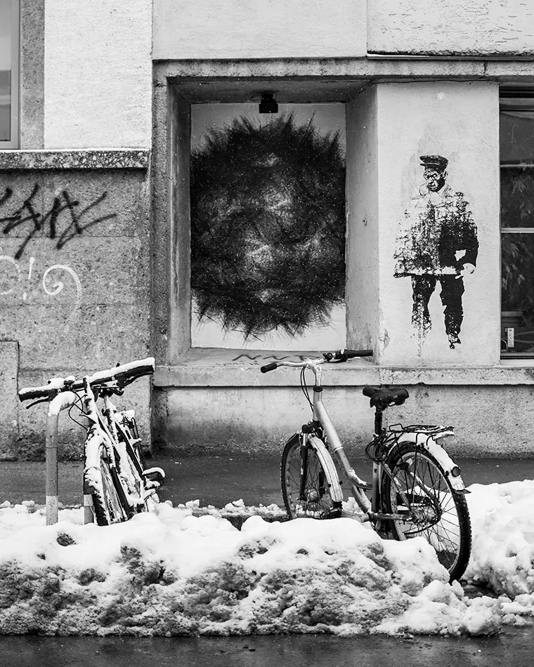 Gekleisterter Digitaldruck von explosionsförmiger schwarzer Schneeflocke vor der Bäckerei Kulturbackstube Vektorzeichnung