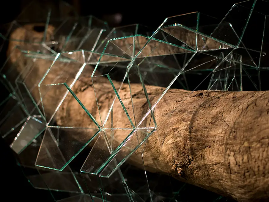 geometrisches Glaskunst-Objekt das ein Stück Treibholz einkapselt Detail