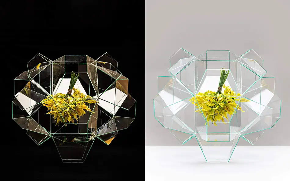 geometrische Glasstruktur mit gelbem Blumenstrauß im Zentrum