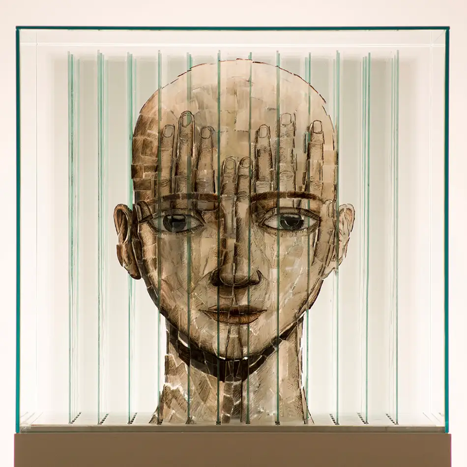 Anamorphic artwork - glass cube with four different images composed of image fragments - face
