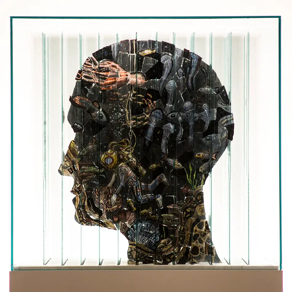 Anamorphic artwork - glass cube with four different images composed of image fragments - head profile with a diver