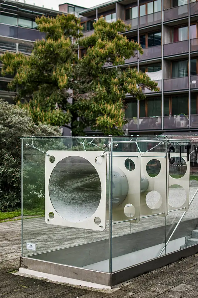 Anamorphe Installation im öffentlichen Raum die in einer Glaseinhausung eines Treppenaufganges einer Tiefgarage hängt