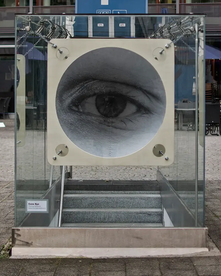 Anamorphe Installation im öffentlichen Raum bei der ein Auge in einem Kegel sichtbar ist - Frontalansicht