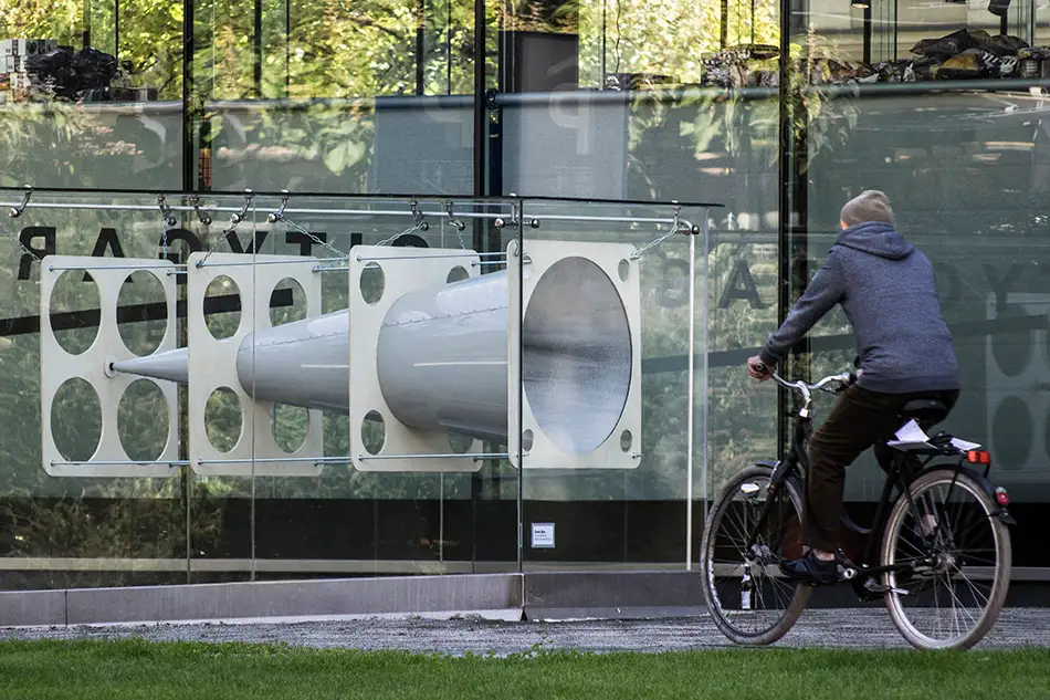 Anamorphic installation in public space in which an eye is visible in a cone - the installation with a person on a bike