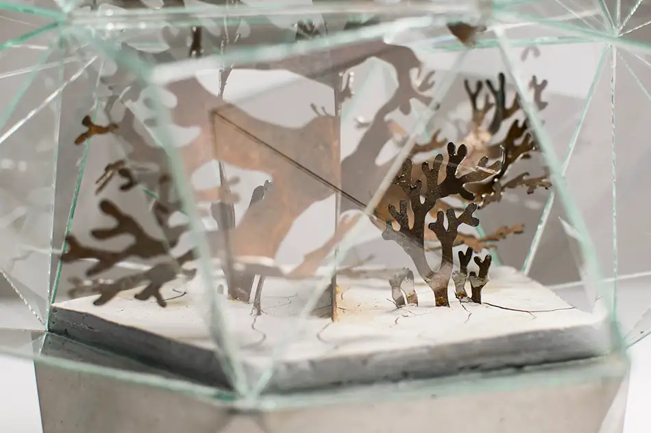 Kunstwerk das an ein Gewächshaus erinnert, bestehend aus einer geometrischen Glasumhausung, einem Beton-Sockel und einer pflanzenartigen Stahl-Struktur - Detail
