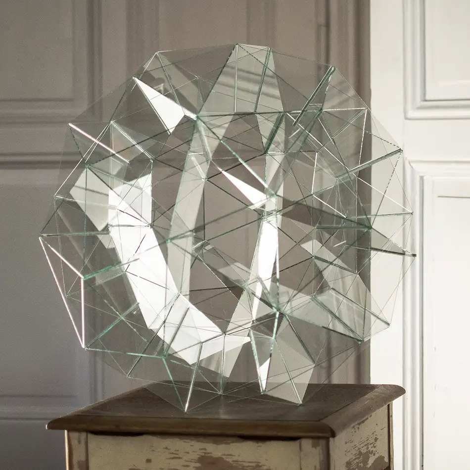 kugelförmige Glasskulptur die geometrisch auf der geodätische Kuppel basiert - liegend auf Stuhl