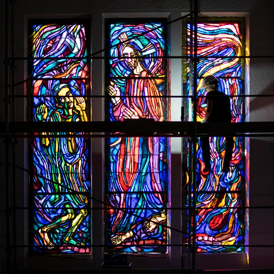 Restauration der Bleiverglasungen im Priesterseminar Innsbruck - Fenster mit Baugerüst und Person im Vordergrund