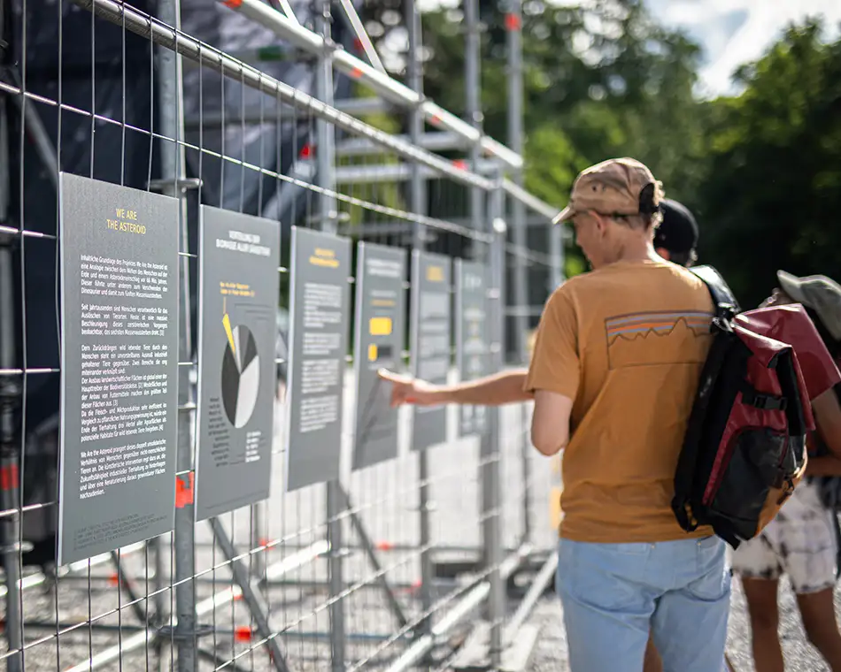 We Are the Asteroid - Kunst im öffentlichen Raum - Personen vor Beschreibungstafeln