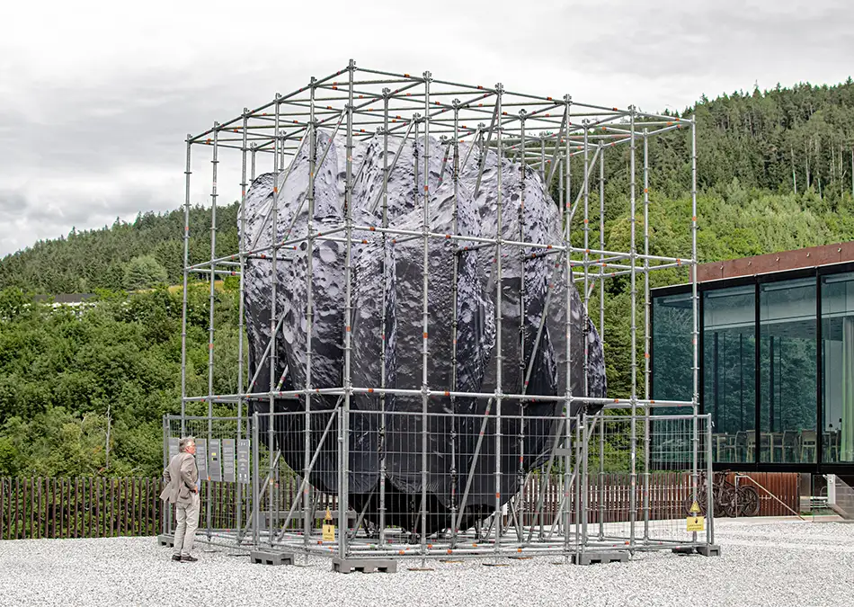 We Are the Asteroid - Art in public space - An asteroid in a scaffolding structure with person